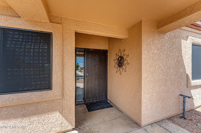 doorway to property featuring stucco siding