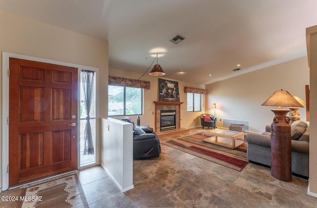 living room featuring baseboards, visible vents, and a tile fireplace