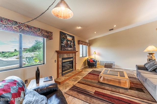 living room featuring a tile fireplace, visible vents, baseboards, and recessed lighting