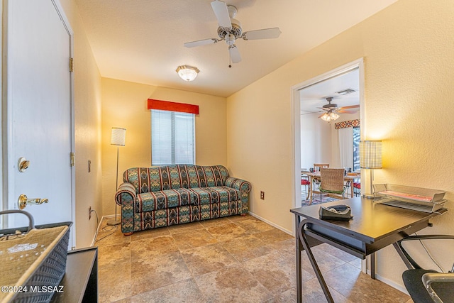 living room with ceiling fan, visible vents, and baseboards