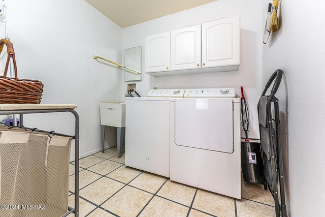 laundry room featuring light tile patterned floors, cabinet space, and separate washer and dryer