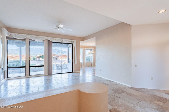 unfurnished room featuring ceiling fan with notable chandelier and plenty of natural light