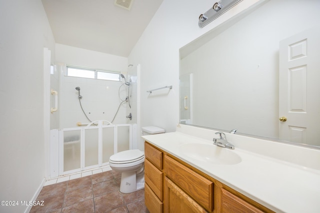 bathroom featuring tile patterned flooring, vanity, vaulted ceiling, toilet, and walk in shower