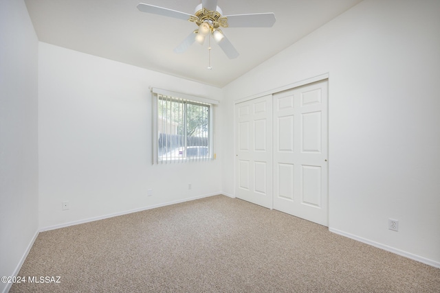 unfurnished bedroom featuring vaulted ceiling, carpet flooring, ceiling fan, and a closet