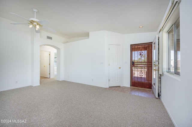 spare room featuring lofted ceiling, light carpet, and ceiling fan