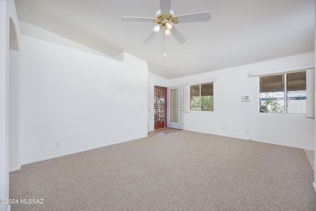 unfurnished room with light carpet, vaulted ceiling, and ceiling fan