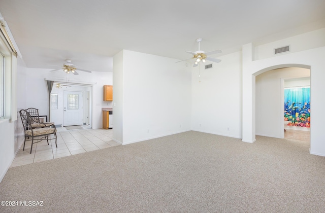 unfurnished living room featuring light carpet and ceiling fan