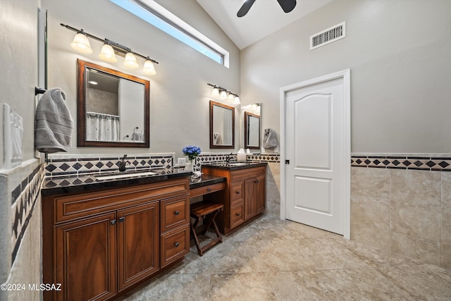 bathroom featuring lofted ceiling, vanity, tile walls, and ceiling fan