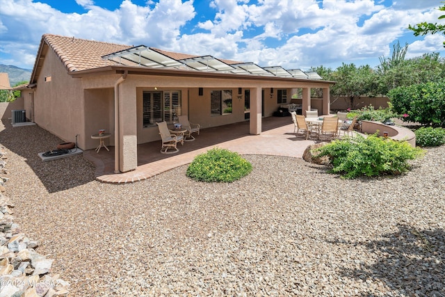 back of property with a patio and central AC