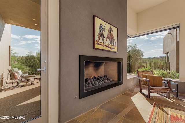 living area with exterior fireplace and tile patterned flooring