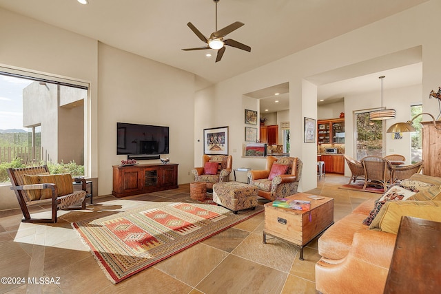 living room with plenty of natural light, light tile patterned floors, and ceiling fan