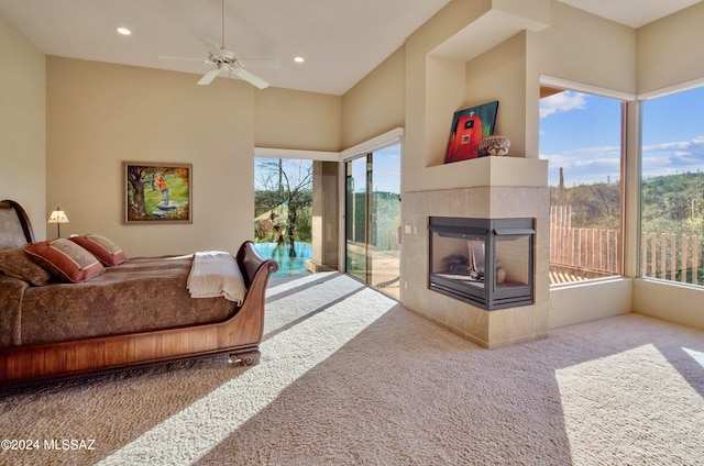 carpeted living room featuring a healthy amount of sunlight, ceiling fan, and a tile fireplace