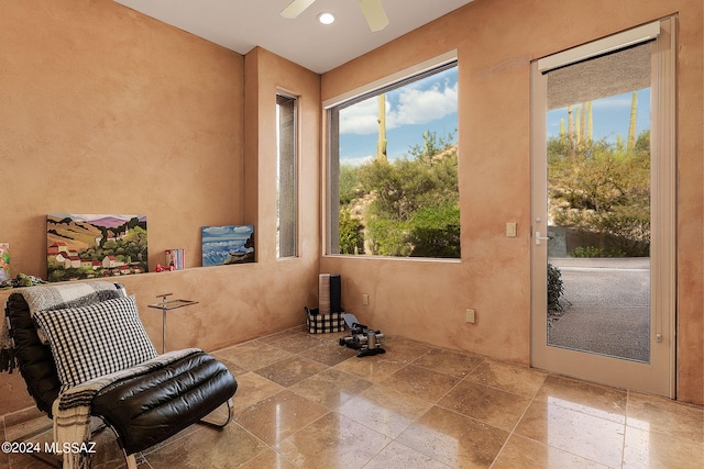 living area with ceiling fan and a healthy amount of sunlight