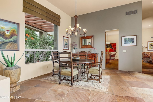 dining room with a healthy amount of sunlight, a chandelier, and a high ceiling