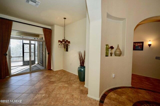 tiled entryway with an inviting chandelier