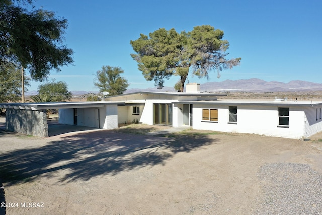 ranch-style home featuring a carport and a mountain view