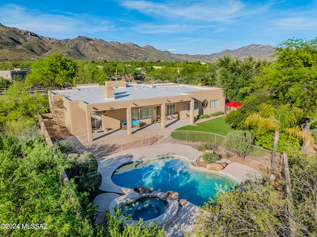 view of swimming pool featuring an in ground hot tub, a mountain view, and a patio area