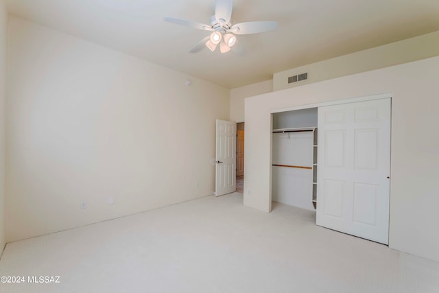 unfurnished bedroom featuring light carpet, a closet, and ceiling fan