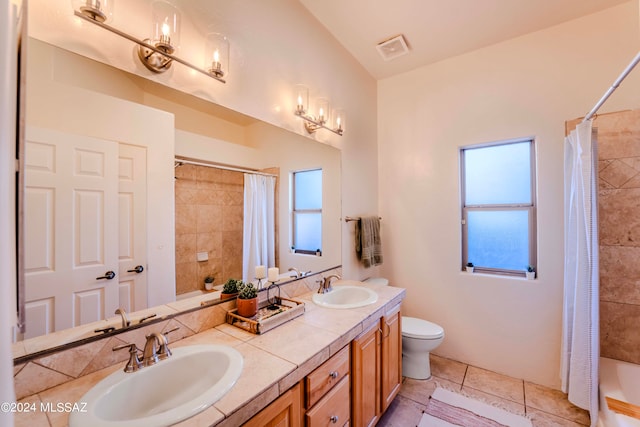 full bathroom with double sink vanity, toilet, shower / tub combo with curtain, and tile patterned flooring