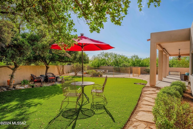 view of yard featuring ceiling fan and a patio area