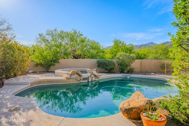 view of pool with an in ground hot tub and a mountain view