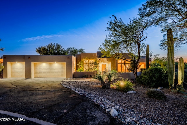 pueblo-style home featuring a garage