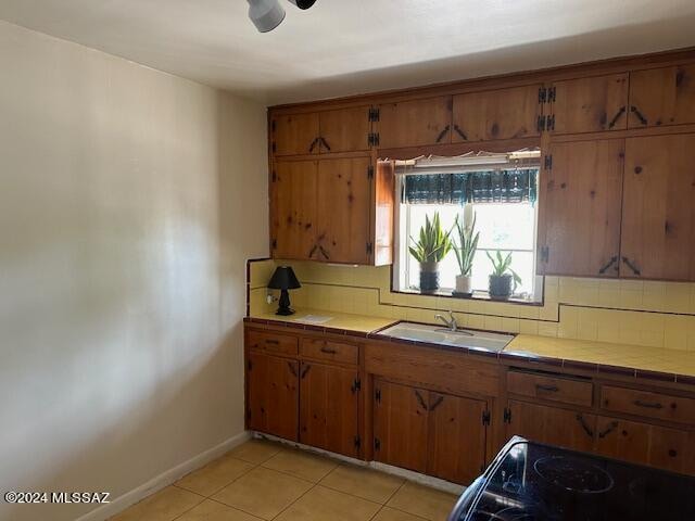 kitchen with sink, tile countertops, decorative backsplash, and light tile patterned floors