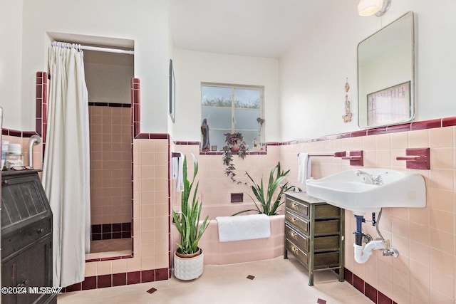 bathroom with decorative backsplash, sink, tile patterned floors, curtained shower, and tile walls