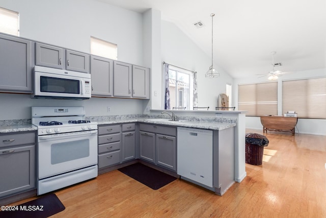 kitchen with pendant lighting, sink, white appliances, gray cabinets, and kitchen peninsula