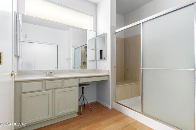 bathroom featuring vanity, hardwood / wood-style floors, and a shower with shower door