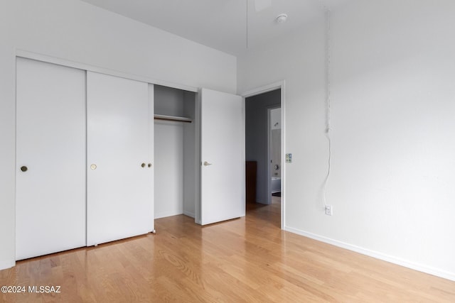 unfurnished bedroom with light wood-type flooring and a closet