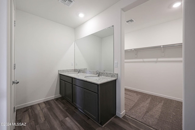 bathroom with hardwood / wood-style flooring and dual vanity