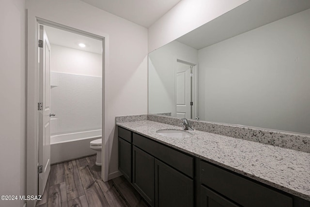 full bathroom featuring toilet, vanity, hardwood / wood-style flooring, and bathing tub / shower combination