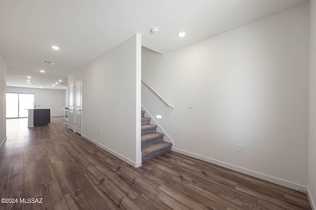 stairway with dark hardwood / wood-style flooring