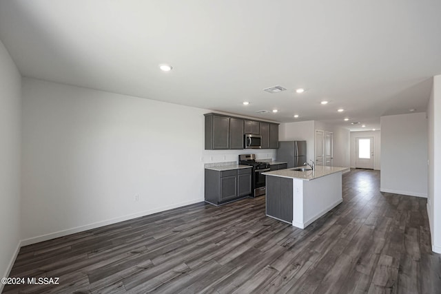 kitchen featuring stainless steel appliances, dark hardwood / wood-style flooring, a center island with sink, gray cabinets, and sink