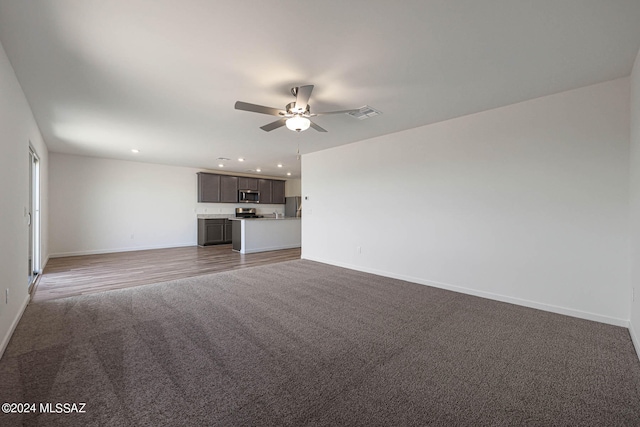 unfurnished living room with carpet and ceiling fan