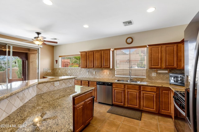 kitchen with brown cabinets, backsplash, visible vents, appliances with stainless steel finishes, and ceiling fan