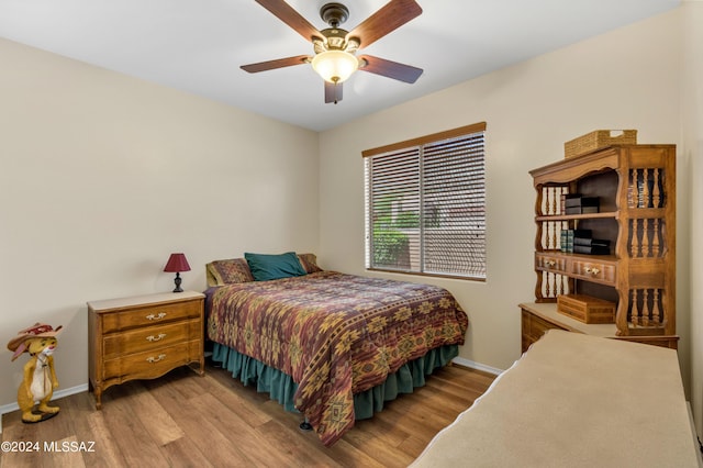 bedroom with light wood-type flooring, baseboards, and ceiling fan