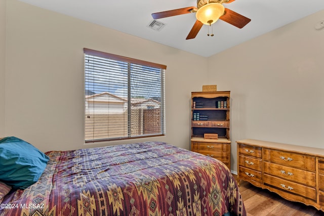 bedroom featuring visible vents, light wood finished floors, and a ceiling fan