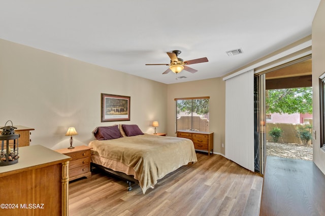 bedroom featuring light wood-type flooring, visible vents, a ceiling fan, and access to exterior
