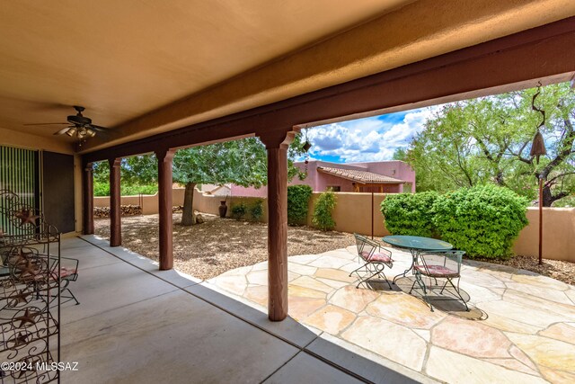 view of patio featuring outdoor dining space, a fenced backyard, and a ceiling fan