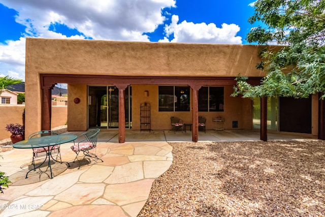 rear view of property with a patio area and stucco siding