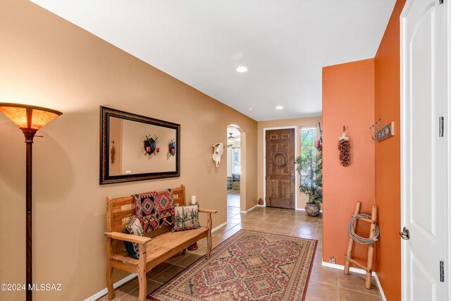 foyer with baseboards, arched walkways, light tile patterned flooring, and recessed lighting
