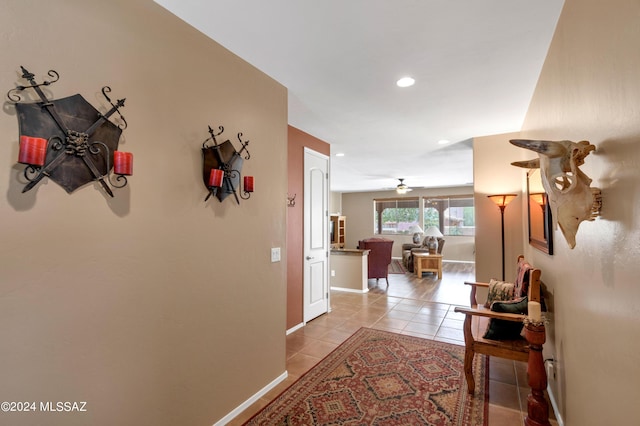 corridor with baseboards, light tile patterned flooring, and recessed lighting