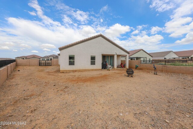 back of property with an outdoor fire pit