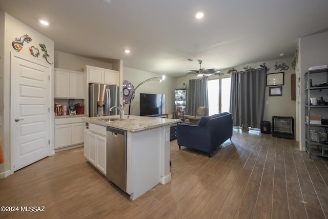 kitchen featuring stainless steel appliances, sink, a center island with sink, and white cabinets