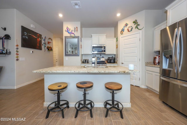 kitchen with white cabinetry, an island with sink, appliances with stainless steel finishes, and sink