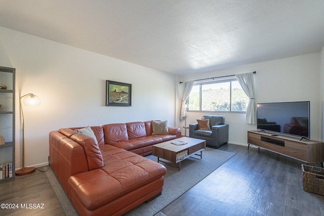 living room with dark hardwood / wood-style floors and a textured ceiling