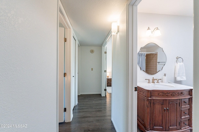 hall featuring sink, dark hardwood / wood-style floors, and a textured ceiling