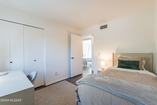 bedroom featuring dark wood-type flooring and a closet